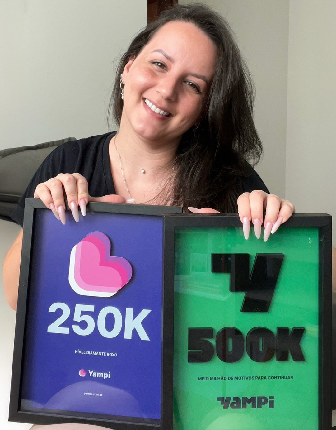 Fundadora da LabKo segurando placas de reconhecimento de R$250k e R$500k em vendas